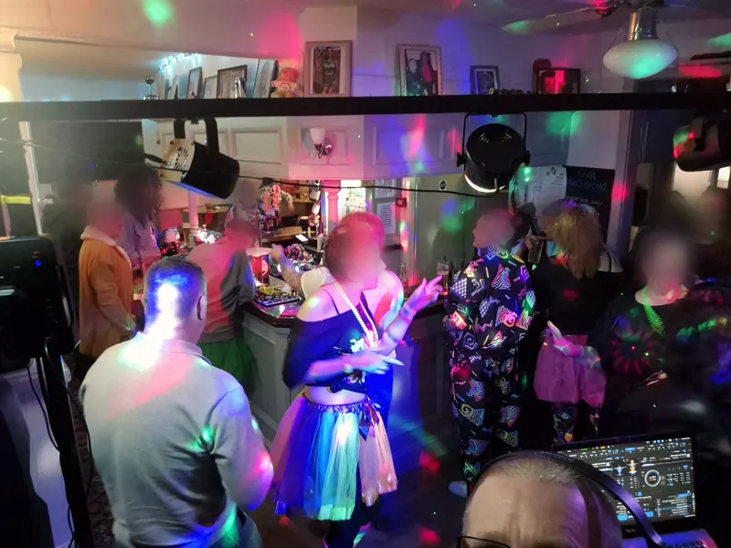 The dance floor in full swing, seen over the DJ decks